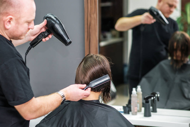 Profesyonel kuaförün yakın çekimleri kadın saçlarını kurutuyor.. - Fotoğraf, Görsel