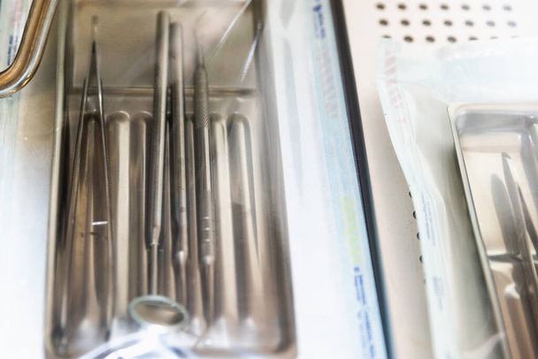 Steril ambalajlı diş aletleri bulanık arkaplanlı. - Fotoğraf, Görsel