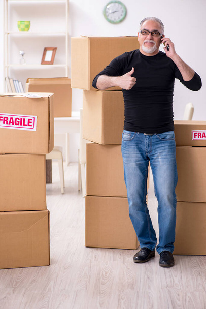 Vieux déménageur professionnel masculin faisant déménagement à la maison - Photo, image