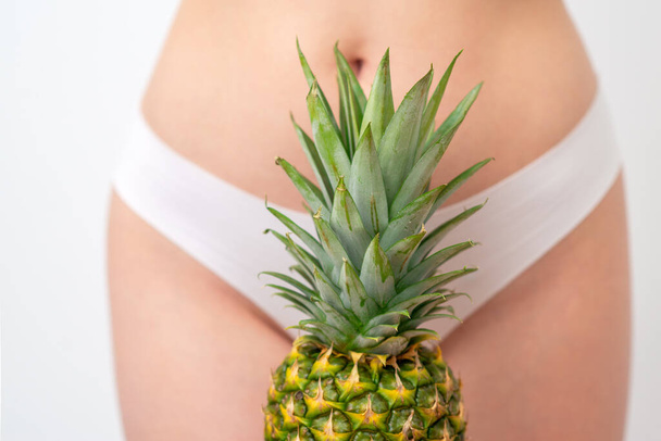Pineapple on woman's body in white panties background, epilation concept, intimate hygiene. - Photo, Image