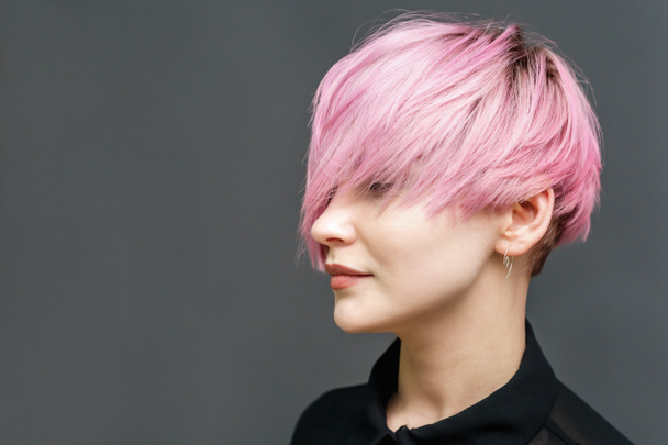 Студійний знімок рожевого волосся біла дівчина з червоною помадою на губах, макіяж і гарне волосся стоїть із закритими очима, копіювання простору
. - Фото, зображення