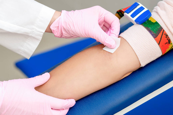 Enfermeira que desinfecta a pele do braço antes de administrar uma vacina injectável no centro médico
. - Foto, Imagem