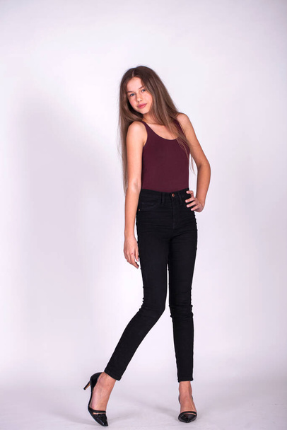 Full body portrait of a young beautiful blonde model in black jeans, isolated on white background - Foto, Bild