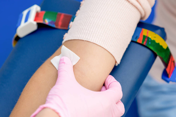 医療センターで注射ワクチンを投与する前に腕の皮膚を消毒看護師. - 写真・画像
