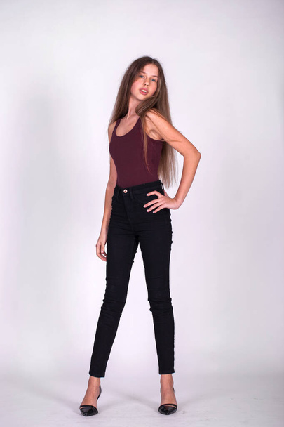 Full body portrait of a young beautiful blonde model in black jeans, isolated on white background - Foto, Imagem
