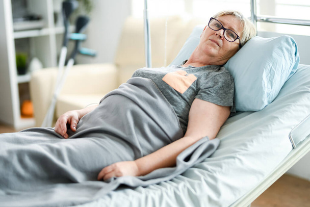 Vanhuus nainen makaa sängyllä hoitokodissa
 - Valokuva, kuva