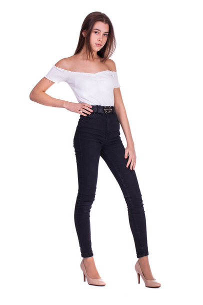 Full body portrait of a young beautiful brunette model in blue jeans, isolated on white background - 写真・画像