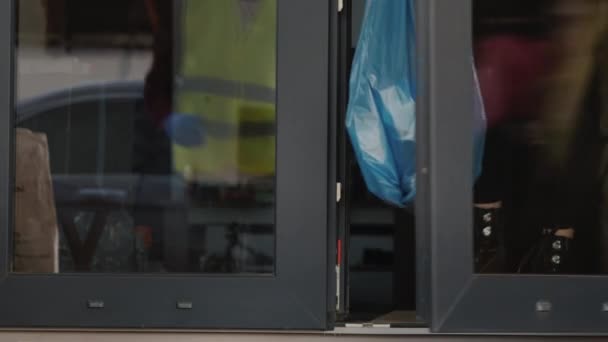 Il volontario raccoglie un sacco della spazzatura davanti alla porta di casa dove le persone sono auto-isolate - Filmati, video