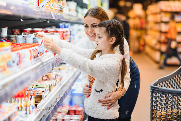Mother with daughter at a grocery store - Photo, image