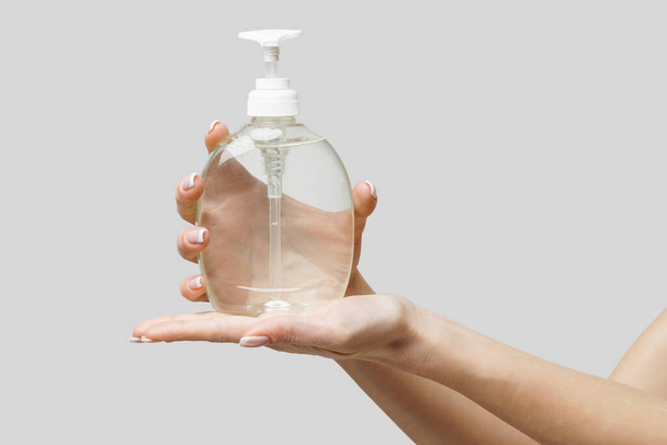Female hands using hand sanitizer gel or liquid soap dispenser over light grey background - Photo, image