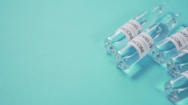 Pět ampulek s koronavirovou vakcínou na modrém pozadí. Dolly shot closeup - Záběry, video