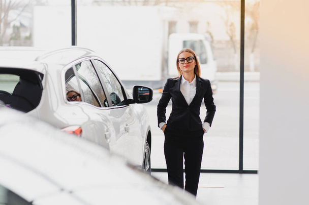 business woman in auto salon. concept of female driver - Fotoğraf, Görsel
