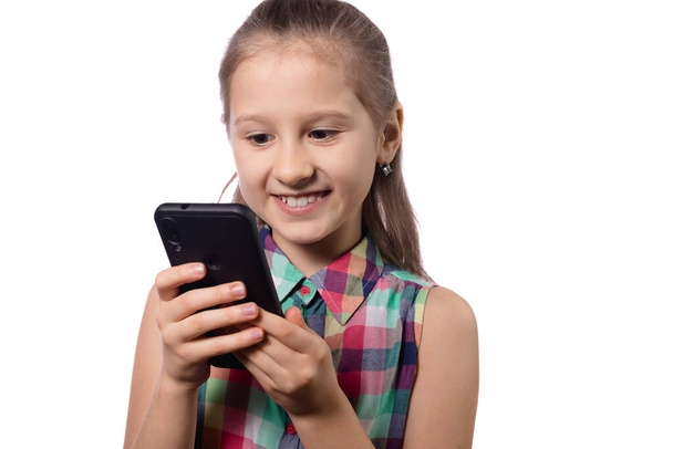 Roztomilé holčička pomocí mobilního telefonu na bílém pozadí. Studio shot. - Fotografie, Obrázek