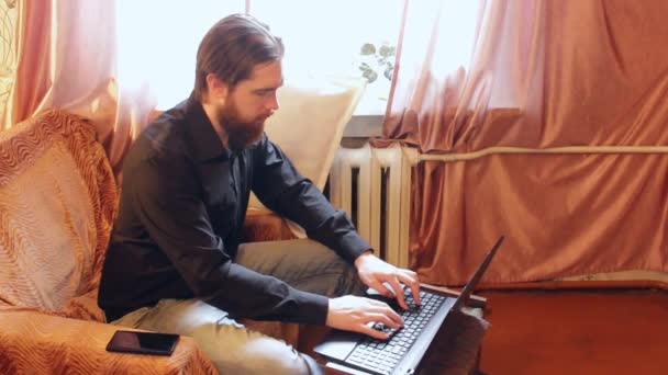 self-isolation mode in the world due to the coronavirus problem.a man with dark hair and a thick beard, works at home as a self-employed remote worker.laptop and phone,bad emotions of anger and fear - Filmati, video