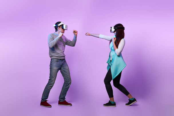 Coppia con cuffie realtà virtuale stanno giocando e combattendo
. - Foto, immagini