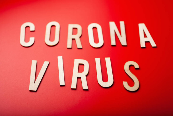 coronavirus woord tekst houten brief op rode achtergrond corona virus covid-19 - Foto, afbeelding