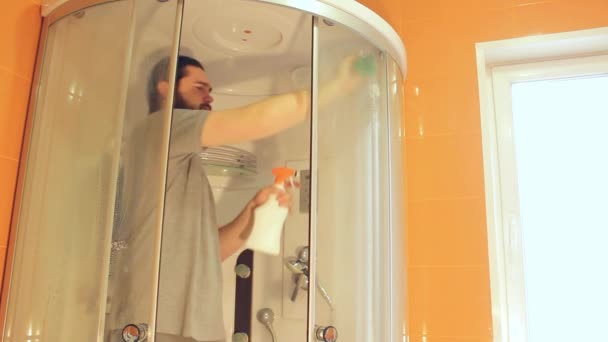 Υγειονομικός καθαρισμός της καμπίνας ντους για την ασφάλεια στο σπίτι κατά τη διάρκεια του coronavirus. Ένας άνδρας με γκρι t-shirt και γενειάδα, απολυμαίνει το μπάνιο.Ένα ισχυρό ανοσοποιητικό σύστημα για καλή υγεία. - Πλάνα, βίντεο