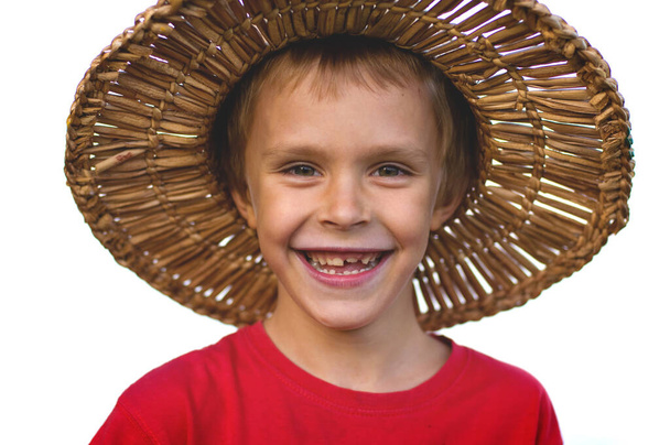 sedmiletý chlapec se radostně usměje a dívá se přímo do kamery - Fotografie, Obrázek
