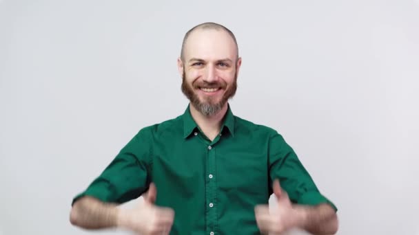 白い背景に親指を立てたシャツを着た幸せな髭の男。いい仕事だよ. - 映像、動画