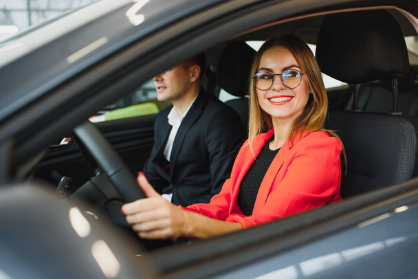 business woman buys a car at a car dealership. Concept of happy business people - Foto, Bild