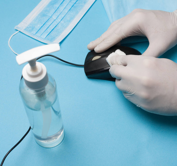 Zbliżenie dezynfekcji, czyszczenie myszy komputerowej w białych rękawiczkach. Zapobieganie zakażeniom koronawirusami. - Zdjęcie, obraz