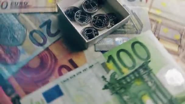 Az eurobankjegyek forognak vagy forognak. Ukrán hrivna érmék kis dobozban. Gazdagság, gazdasági válság, nemteljesítés, beruházás, siker vagy üzleti koncepció. - Felvétel, videó