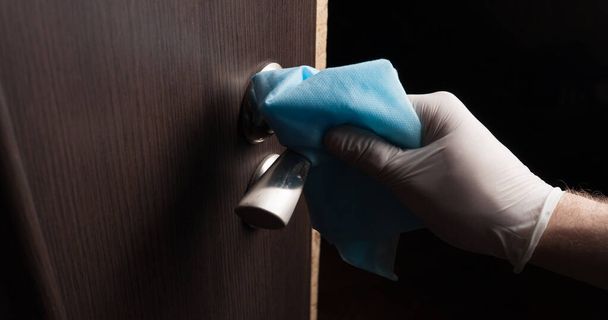 Primo piano della disinfezione, pulizia e lavaggio delle maniglie delle porte con guanti bianchi. Prevenzione delle infezioni da coronavirus
 - Foto, immagini
