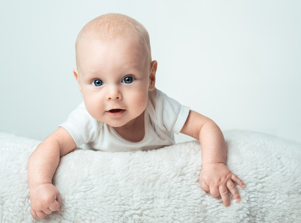 Little infant is smiling on the carpet - Foto, imagen