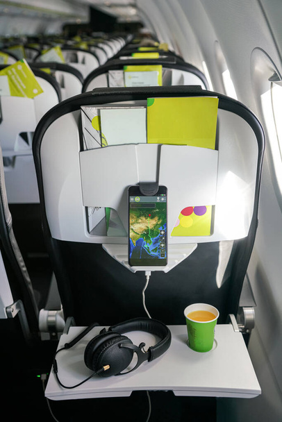 Smartphonebeugel in het vliegtuig. Ontspanningssysteem tijdens de vlucht - Foto, afbeelding