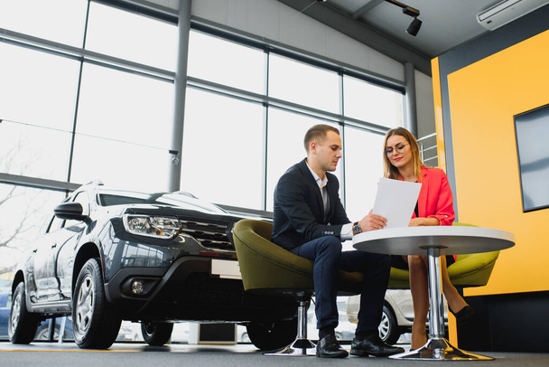 Successful businessman in a car dealership - sale of vehicles to customers - Fotó, kép