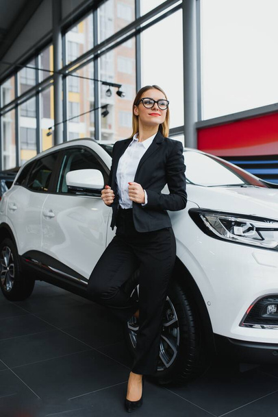 business woman buys a car at a car dealership - Fotoğraf, Görsel