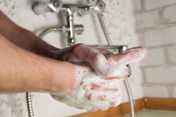 Hygiene and quarantined coronavirus prevention. Male hands close-up in the bathroom. - Fotó, kép