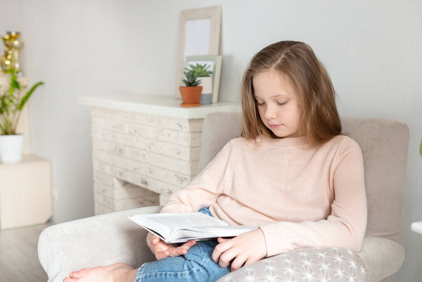 Young teenager girl reading book at home. Distance education, home education. Self isolation concept - Image - Foto, afbeelding