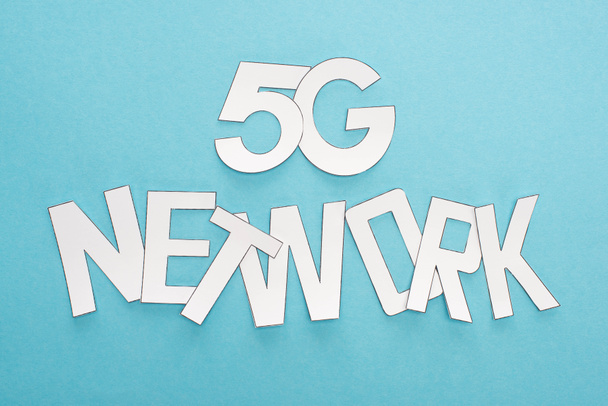 top view of white 5g network lettering on blue background - Fotografie, Obrázek
