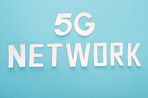 top view of white 5g network lettering on blue background - Foto, afbeelding