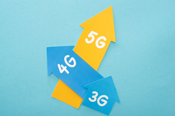 top view of 3g, 4g and 5g arrows on blue background - Fotoğraf, Görsel