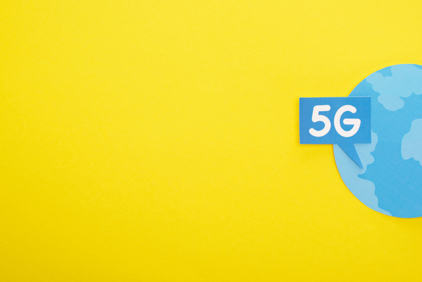 top view of speech bubble with 5g lettering near blue globe on yellow background - Photo, Image