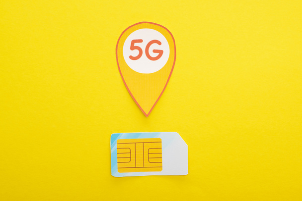 top view of sim card and 5g lettering on yellow background - Photo, Image
