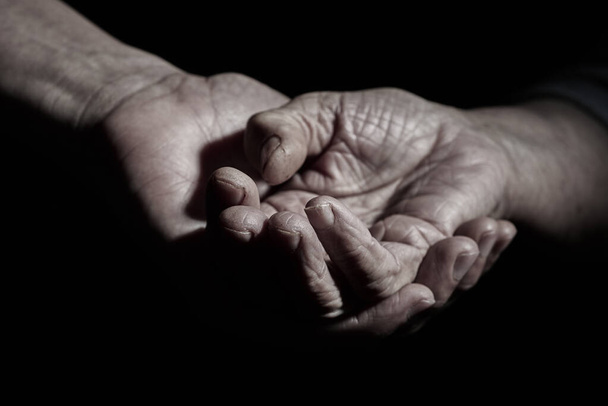 Крупный план молодого кавказца, держащего за руку старшую кавказскую женщину
 - Фото, изображение