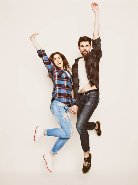 life style, happiness and people concept: Happy loving couple. Jumping over light grey background. - Fotografie, Obrázek