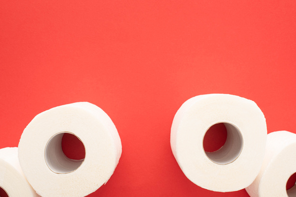top view of white toilet paper rolls on red background with copy space - Fotografie, Obrázek