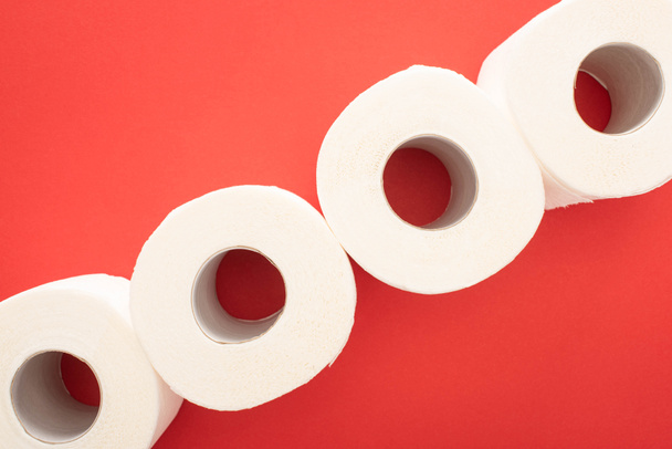 top view of white toilet paper rolls on red background - Foto, afbeelding