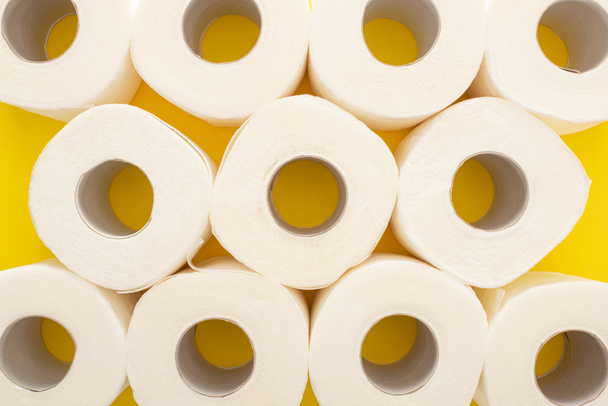 top view of white toilet paper rolls on yellow background - Photo, Image