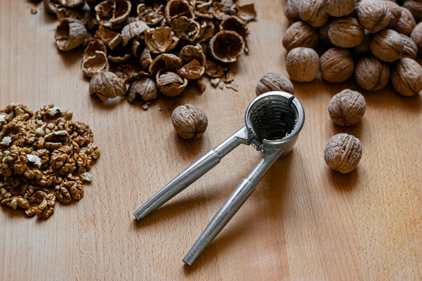 walnuts and nutcracker on wooden background - Photo, Image