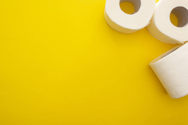 верхний вид чистых рулонов туалетной бумаги на желтом фоне с копировальным пространством
 - Фото, изображение