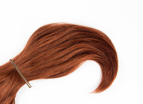 Puhdas tasainen lay studio näkymä yksinkertainen laaja curl osa valmistettu rehevä viininpunainen hiukset eristetty valkoisella pohjalla kopiotilaa. Hiustyyli tuotteiden tausta design elementti käsite
. - Valokuva, kuva