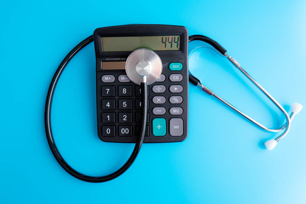 витрати на охорону здоров'я. Стетоскоп і символ калькулятора витрат на охорону здоров'я або медичне страхування
 - Фото, зображення