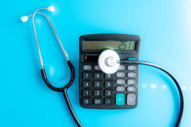 Custos de cuidados de saúde. Estetoscópio e calculadora símbolo para custos de cuidados de saúde ou seguro médico
 - Foto, Imagem