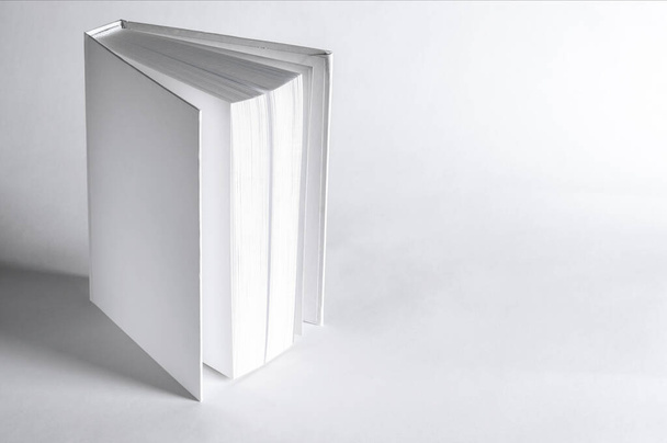 Mockup zárt üres négyzet könyv fehér texturált papír háttér. Üres négyzet borító könyv sablon fehér háttér - Fotó, kép