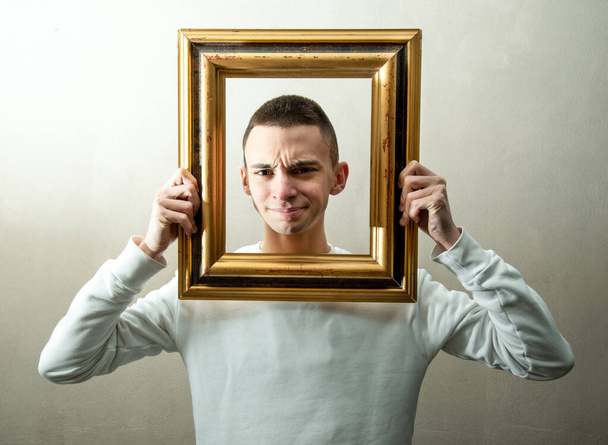 a boy with strange expression with a frame around his face - Foto, afbeelding